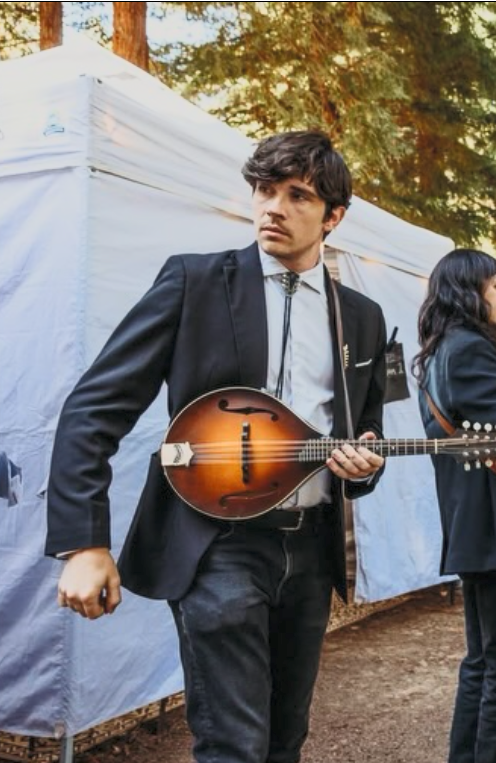 John Seltzer with mandolin looking behind outdoors